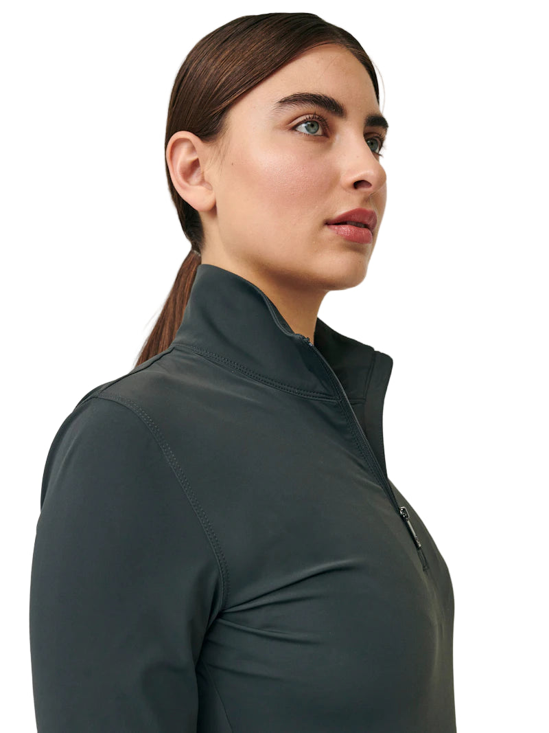 Woman wearing a dark green zip-up shirt against a plain background