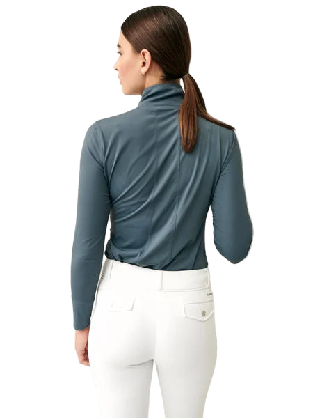 Person wearing a blue long-sleeve top and white pants on a light background